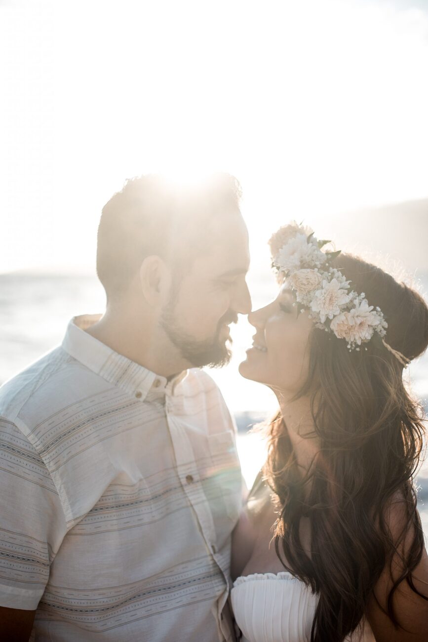 Jessie Hawaii Photography, Romantic couple embracing at sunset, woman wearing flower crown.