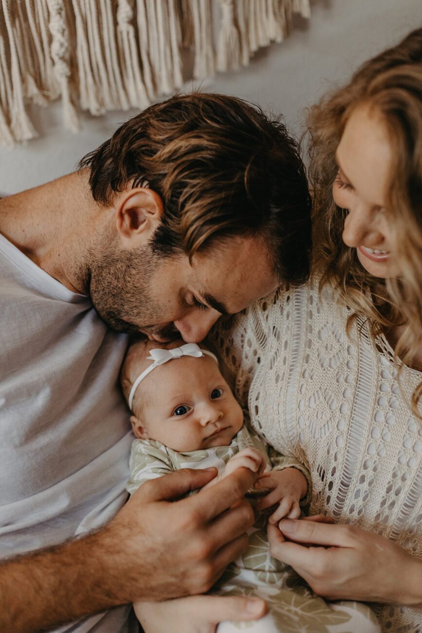 Jessie Hawaii Photography, Loving parents embrace their newborn baby. Maui family photographer.