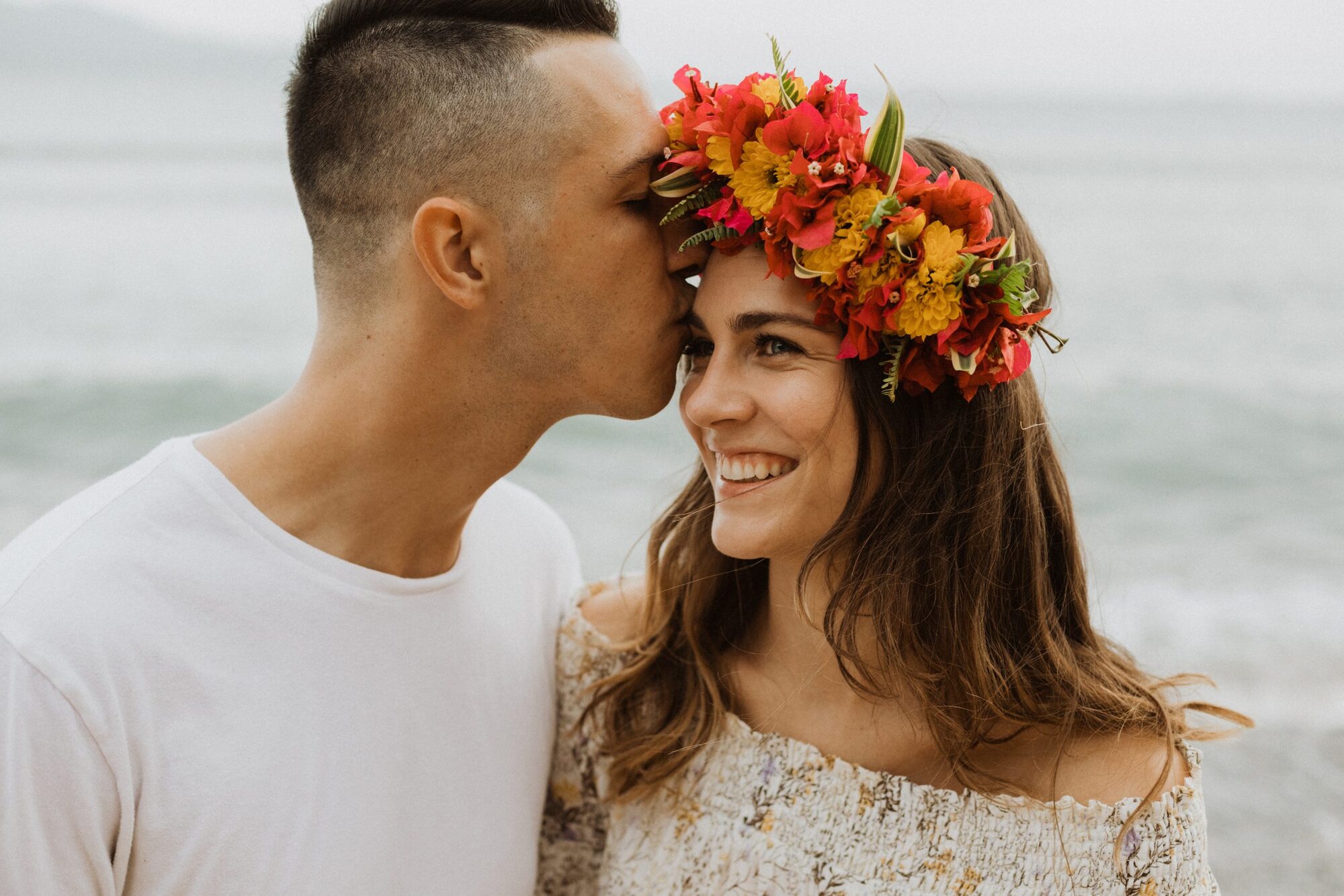 Jessie Hawaii Photography, Man kissing woman's forehead; she wears a floral crown.