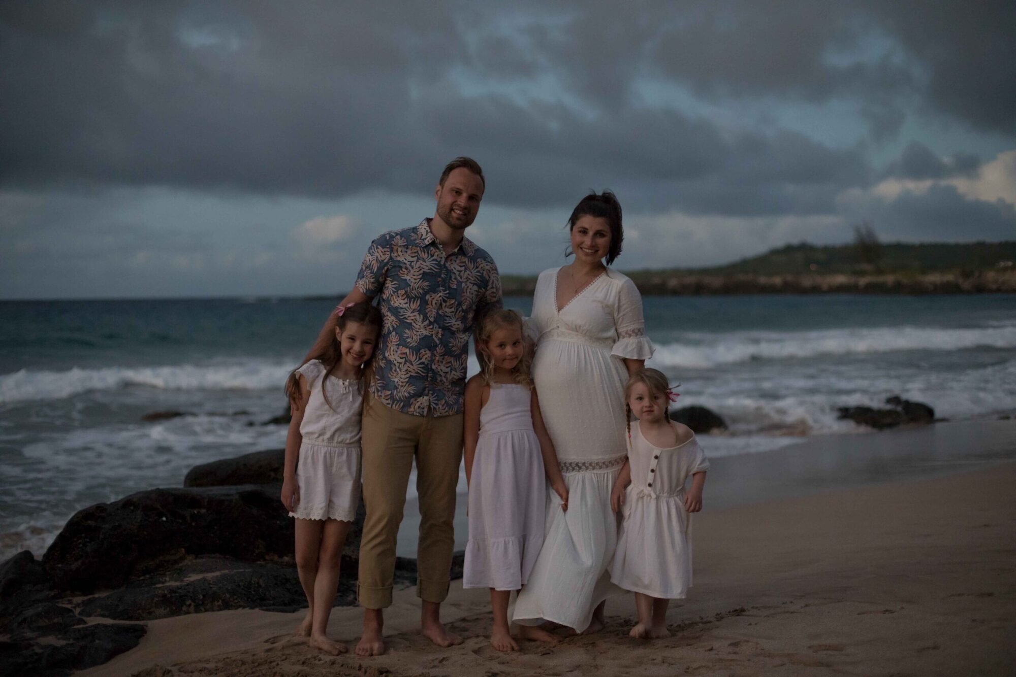 Jessie Hawaii Photography, Happy family of five on a beach at sunset. Pregnant mother, father, and three daughters.