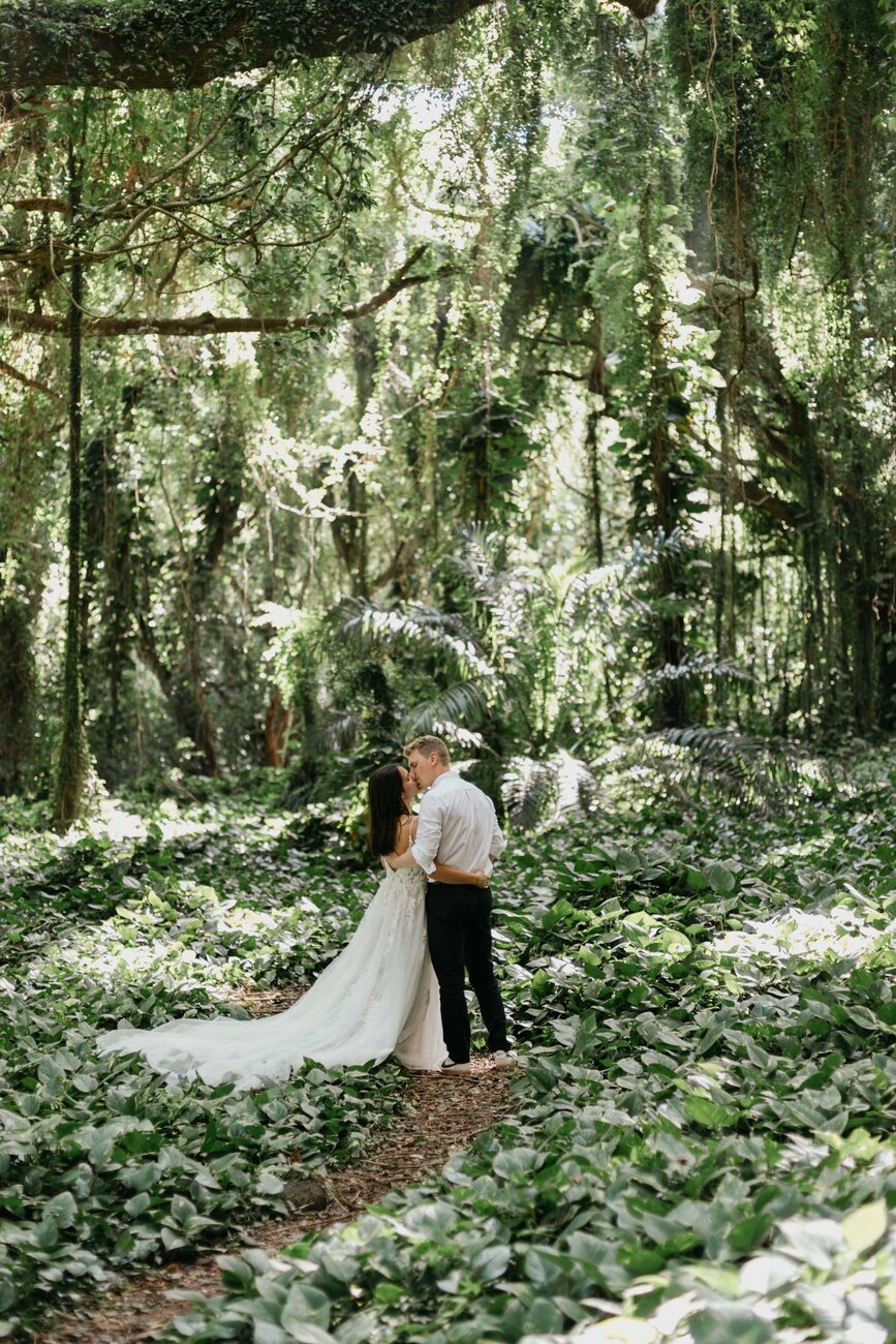 Jessie Hawaii Photography, Bride and groom kiss in lush green forest, wedding photography